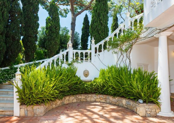 Staircase down from living room balcony to pool area